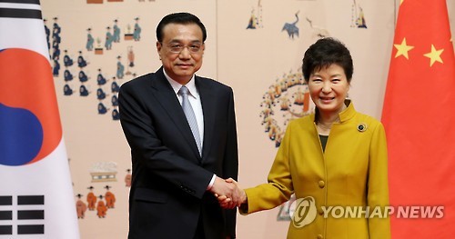 资料图片：10月31日，在青瓦台，韩国总统朴槿惠和中国国务院总理李克强在举行会谈前握手合影。（韩联社）