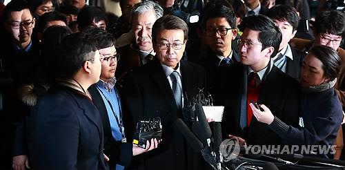 Jeong Yun-hoe (C) answers questions from reporters before entering Seoul District Prosecutors' Office in southern Seoul on Dec. 10, 2014, to face questioning over a document leak. (Yonhap) 