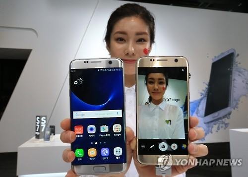 A model poses for a photo with Galaxy S7 smartphones (Yonhap)