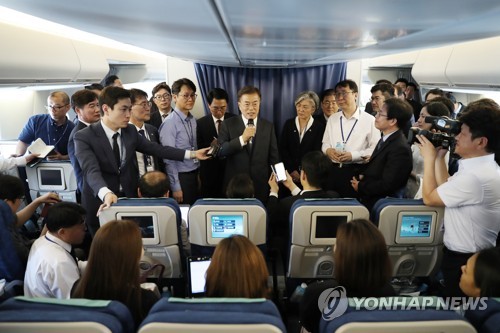 South Korean President Moon Jae-in (holding a mic) speaks to reporters while aboard Air Force One en route to Washington on June 28, 2017, for his summit with U.S. President Donald Trump later in the week. (Yonhap) 
