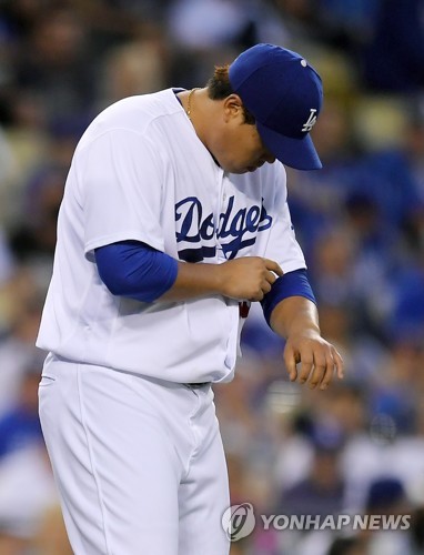 In this Associated Press photo, Ryu Hyun-jin of the Los Angeles Dodgers looks at his left arm after it was hit by a line drive off the bat of Joe Panik of the San Francisco Giants in the top of the third inning in the teams' regular season game at Dodger Stadium in Los Angeles on Sept. 23, 2017. (Yonhap)