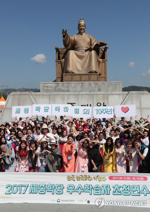 This file photo, taken on Sept. 18, 2017, shows foreign students of Korean language and culture from over 50 countries posing for a photo in downtown Seoul. The students were chosen to visit Korea for their excellent academic performances at overseas branches of the King Sejong Institute, which teaches the language and culture of Korea. Behind them is the statue of King Sejong, the inventor of the Korean alphabet called hangeul. (Yonhap)