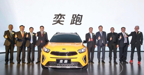 In this photo taken on April 25, 2018, and provided by Hyundai Motor Group, Hyundai Motor Group Vice Chairman Chung Eui-sun (5th from right) and officials from the carmaker and local partners pose beside Kia Motor's YI PAO SUV at the Beijing Motor Show. (Yonhap)