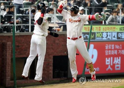 Jamie Romak of the SK Wyverns (R) celebrates his three-run home run against the Doosan Bears with teammate Han Dong-min in the bottom of the first inning of Game 3 of the Korean Series at SK Happy Dream Park in Incheon, 40 kilometers west of Seoul, on Nov. 7, 2018. (Yonhap)