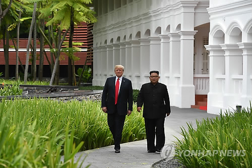 昼食会後、ホテルで散歩する金委員長（右）とトランプ大統領＝１２日、シンガポール（ＡＦＰ＝聯合ニュース）