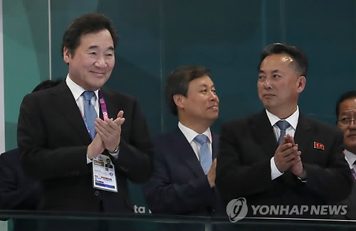 来賓席から拍手を送る韓国の李洛淵首相（左端）と北朝鮮の李龍男副首相（左から３人目）＝１８日、ジャカルタ（聯合ニュース）