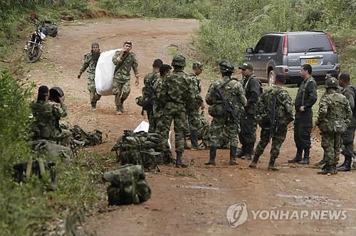 콜롬비아 정부군이 14일 FARC의 공격으로 숨진 병사들의 시신을 옮기고 있다(EPA=연합뉴스)
