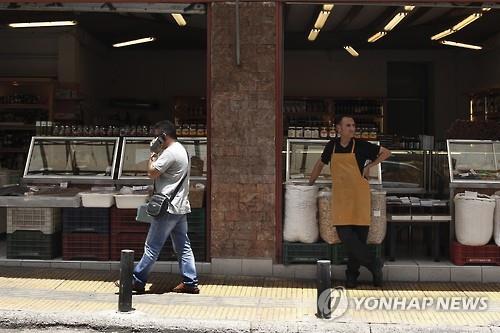 가게 앞에서 손님 기다리는 그리스 상점 주인(EPA=연합뉴스)