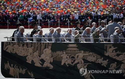 열병식 참여한 중국의 참전 노병들이 대형 무개차량에 앉아 손을 흔들고 있다. (AP=연합뉴스)