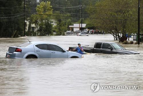 침수된 도로에서 배로 대피하는 주민(AP=연합뉴스)