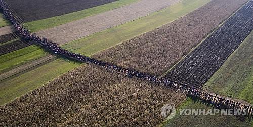 들판 가로질러 가는 난민 행렬