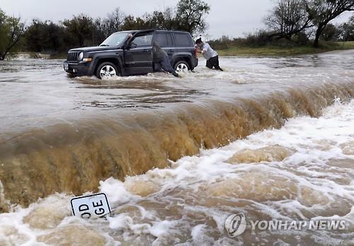 폭우로 불어난 하천에 갇힌 차를 밀어내는 사람들(AP=연합뉴스DB)