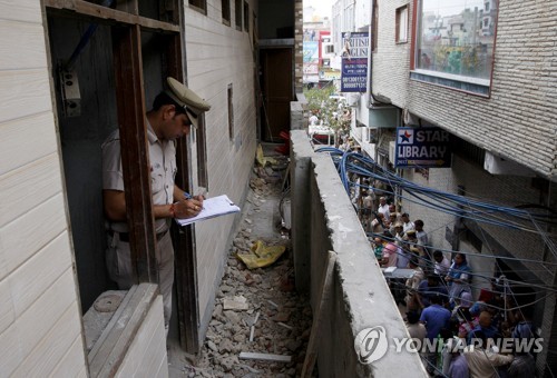1일 인도 경찰이 시신 11구가 발견된 뉴델리 가정집에서조사 내용을 메모하고 있다. / 이하 로이터=연합뉴스