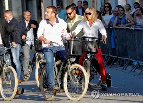 지난 6월 자전거를 탄 모습의 에마뉘엘 마크롱 프랑스 대통령 부부 / 이하 연합뉴스