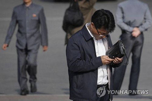 북한 평양에서 휴대전화를 들여다보는 한 남성 [AP=연합뉴스]