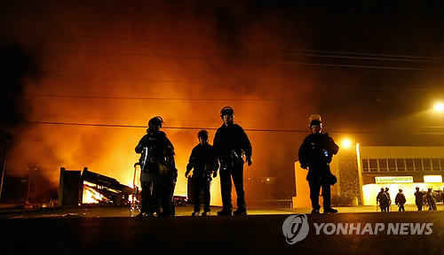 불타는 건물 앞의 경찰들(EPA=연합뉴스)