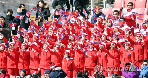 平昌五輪のスキー競技会場で北朝鮮の国旗を振りながら声援を送る北朝鮮応援団＝（聯合ニュース）
