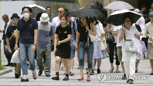 일본 전국에 폭염이 쏟아지는 가운데 도쿄(東京) 긴자(銀座)에서 행인들이 양산을 쓴 채 걸어가고 있다. /교도=연합뉴스 자료사진