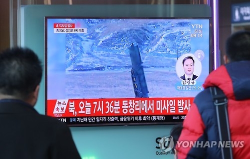 In this photo taken on March 6, 2017, two men watch a news report on North Korea's firing of ballistic missiles into the East Sea early Monday morning. (Yonhap)