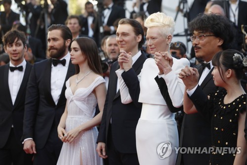 In this AP photo, from right, actress Ahn Seo-hyun, director Bong Joon-ho, actors Tilda Swinton, Paul Dano, Lily Collins, Jake Gyllenhaal and Devon Bostick pose for photographers after their arrival at the screening of the film "Okja" at the 70th Cannes Film Festival in Cannes, southern France, on May 19, 2017. (Yonhap)