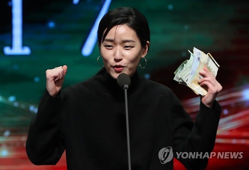 In this file photo, singer-songwriter Lee Lang celebrates on stage at the Korean Music Awards on Feb. 28, 2017, in Seoul after selling the trophy for her Best Folk Song award to an audience. (Yonhap)